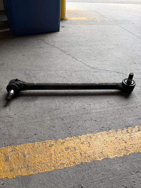 Old drag link lying on concrete after removal