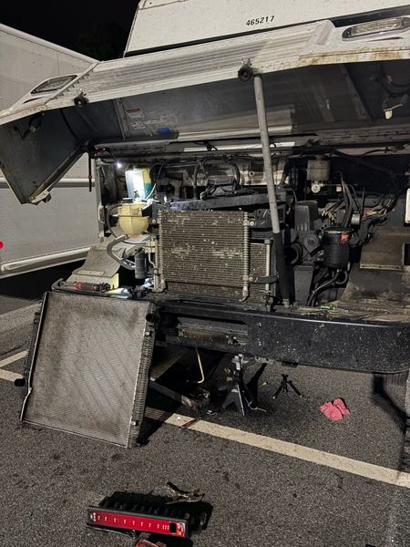 Radiator replacement on a step van at night with the hood open