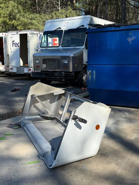 Step van front hood and nose assembly removed and set on the ground